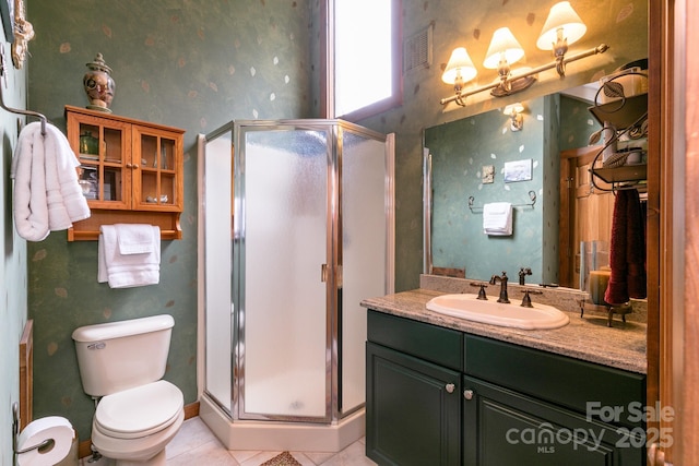 full bathroom featuring a shower stall, wallpapered walls, vanity, toilet, and tile patterned floors