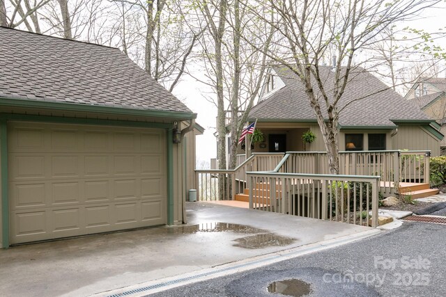 view of front of house with a shingled roof and a garage