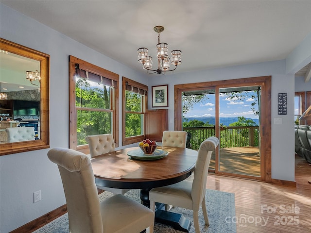 141 Ivy Ridge Rd, Burnsville, NC 28714 - dining space featuring a chandelier, healthy amount of natural light, baseboards, and light wood-style floors
