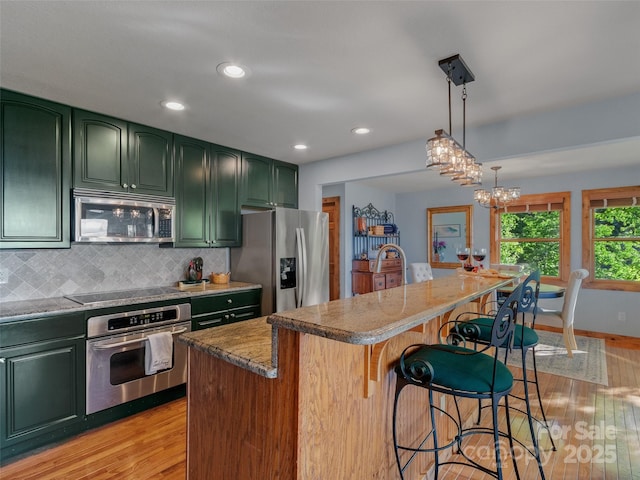 141 Ivy Ridge Rd, Burnsville, NC 28714 - kitchen featuring green cabinets, appliances with stainless steel finishes, light wood finished floors, and recessed lighting
