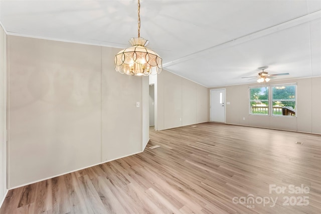 spare room featuring ornamental molding, ceiling fan with notable chandelier, and light wood finished floors