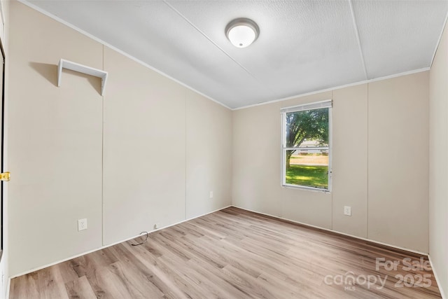 spare room featuring crown molding and wood finished floors
