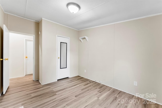 unfurnished room with ornamental molding and light wood-type flooring
