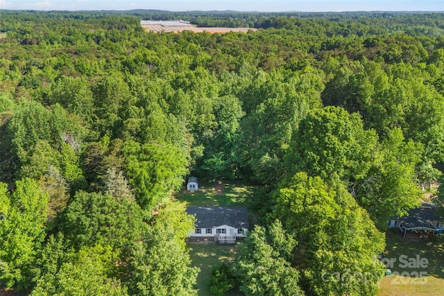 bird's eye view with a wooded view