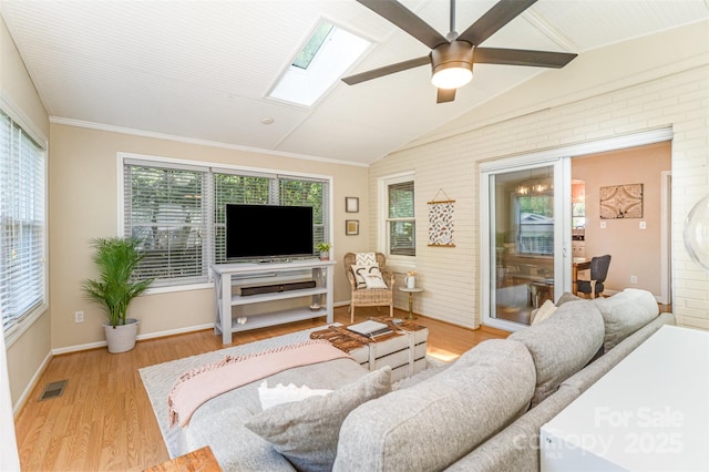 living room featuring a skylight, a ceiling fan, vaulted ceiling, wood finished floors, and plenty of natural light