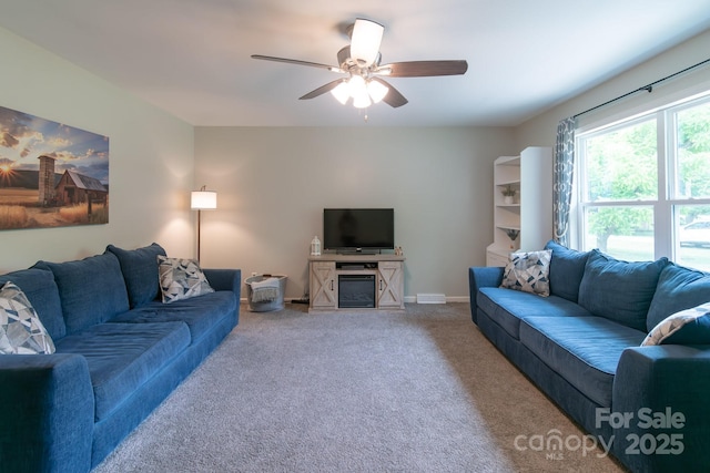 carpeted living room with ceiling fan