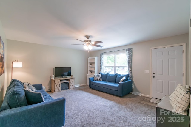 living area featuring carpet floors, ceiling fan, and baseboards