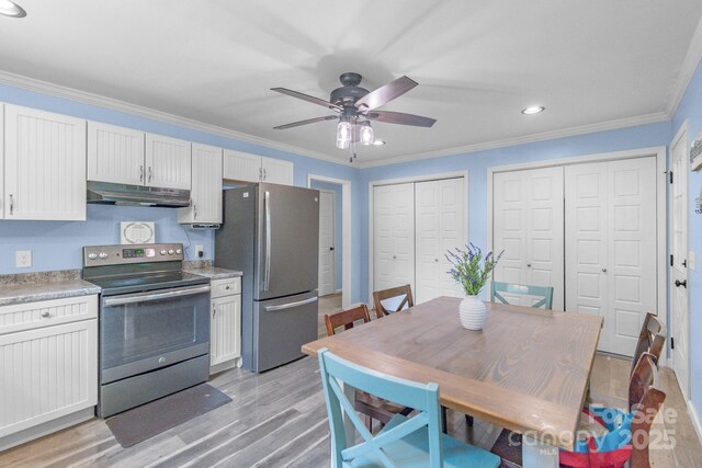 kitchen with appliances with stainless steel finishes, under cabinet range hood, ceiling fan, light wood-style floors, and light countertops