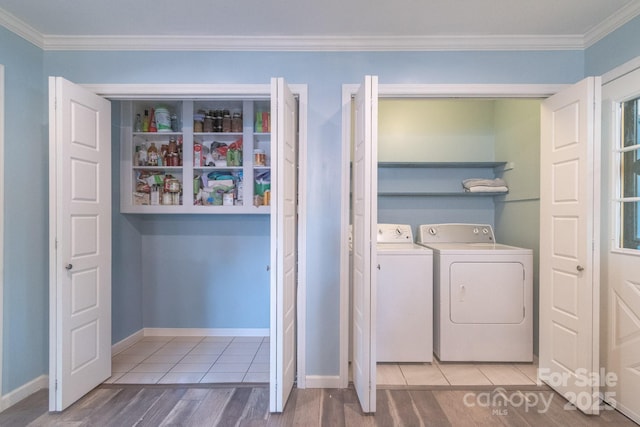 washroom with washing machine and clothes dryer, crown molding, wood finished floors, and baseboards