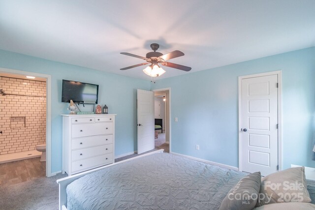 carpeted bedroom with ensuite bath, baseboards, and a ceiling fan