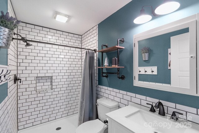 bathroom with tile walls, a shower stall, toilet, vanity, and tasteful backsplash