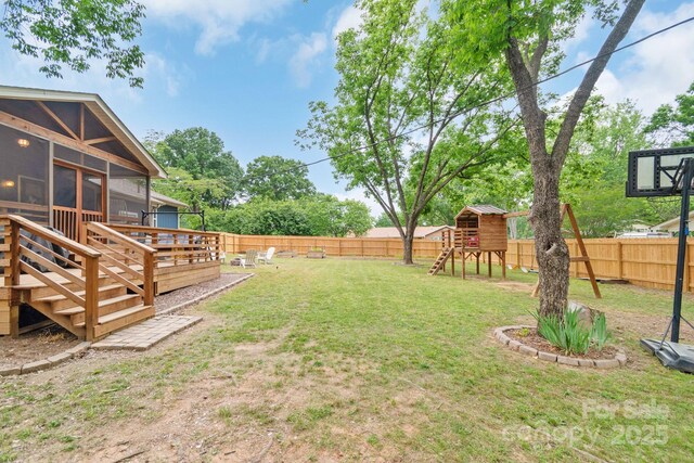 view of yard with a sunroom, a playground, a wooden deck, and stairway