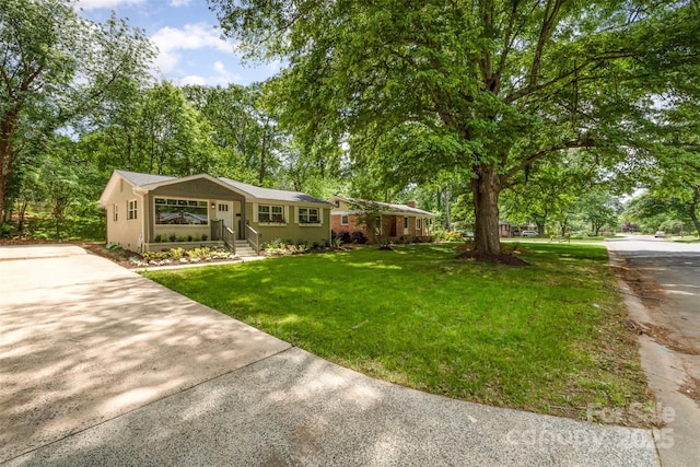 single story home featuring driveway and a front lawn