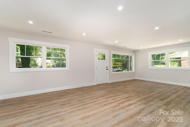 unfurnished living room with visible vents, recessed lighting, baseboards, and light wood-type flooring