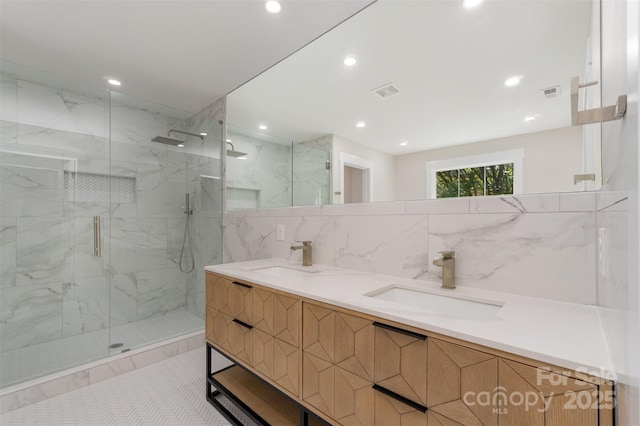 full bathroom featuring recessed lighting, visible vents, a marble finish shower, and a sink