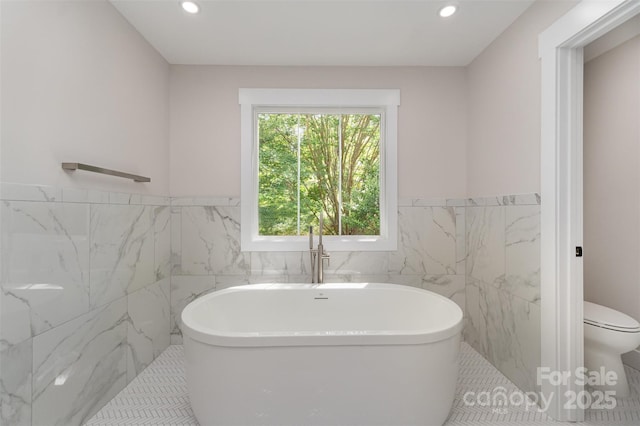 full bathroom with toilet, tile walls, wainscoting, and a freestanding bath