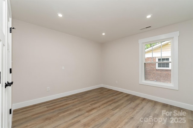 unfurnished room featuring light wood-style floors, baseboards, recessed lighting, and visible vents