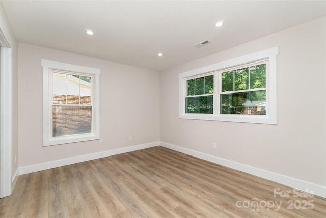 unfurnished room with recessed lighting, baseboards, light wood-type flooring, and visible vents