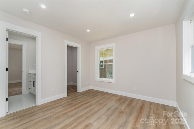 unfurnished bedroom featuring recessed lighting, baseboards, light wood-type flooring, and a spacious closet