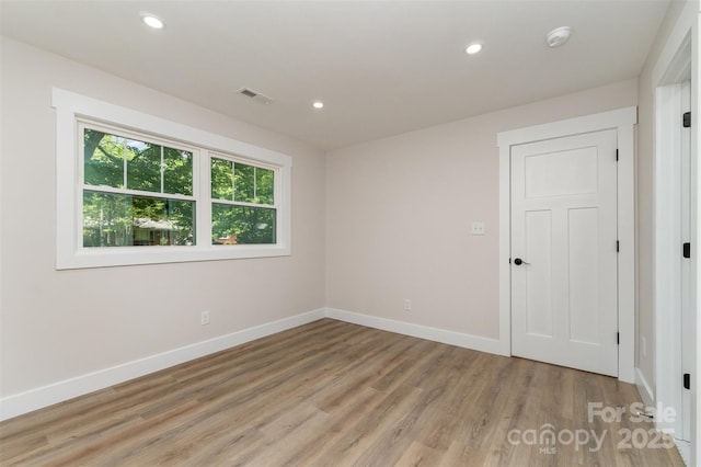 unfurnished room with recessed lighting, baseboards, light wood finished floors, and visible vents