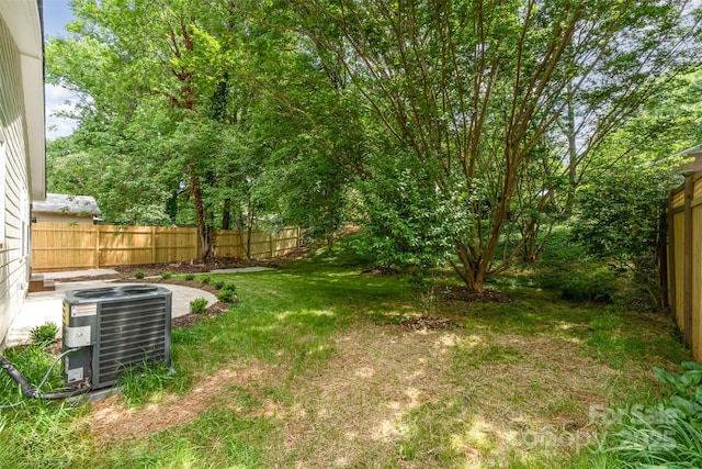 view of yard with fence and central AC unit