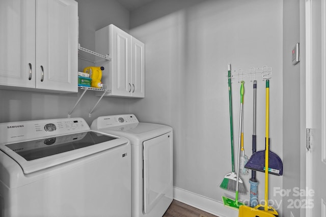 laundry area with cabinet space, washing machine and clothes dryer, dark wood-type flooring, and baseboards