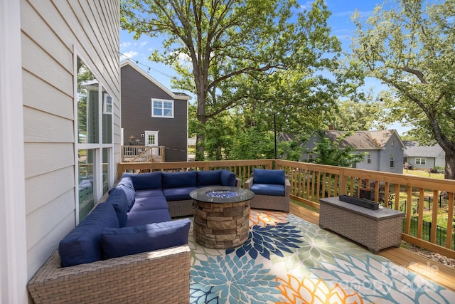 wooden deck with an outdoor living space with a fire pit