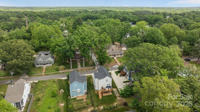 birds eye view of property with a view of trees and a residential view