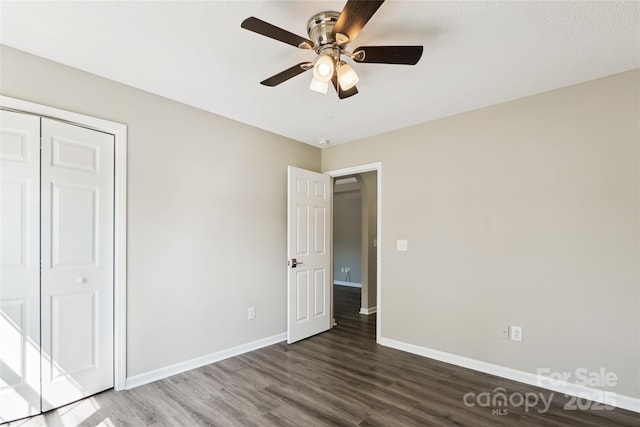 unfurnished bedroom with baseboards, a closet, a ceiling fan, and wood finished floors