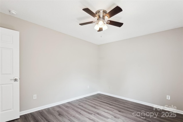 unfurnished room featuring dark wood-type flooring, baseboards, ceiling fan, and a smoke detector
