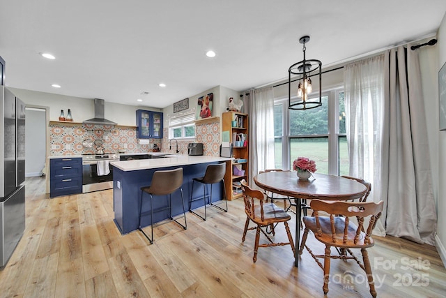456 Rainbow Cir, Clover, SC 29710 - kitchen with stainless steel appliances, wall chimney range hood, open shelves, a sink, and blue cabinets