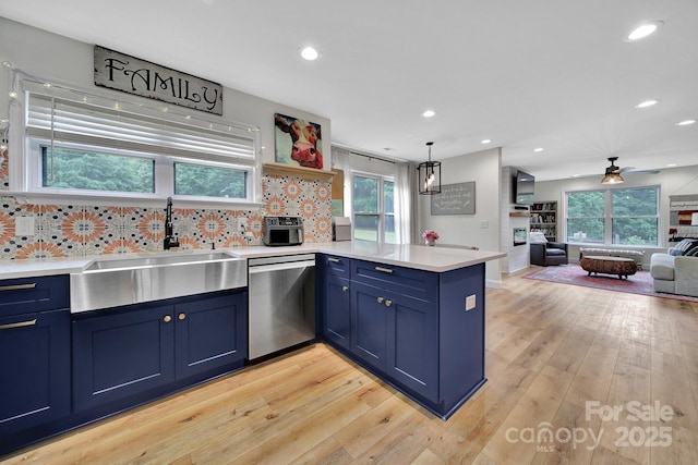 456 Rainbow Cir, Clover, SC 29710 - kitchen featuring stainless steel dishwasher, blue cabinetry, a peninsula, a sink, and decorative backsplash