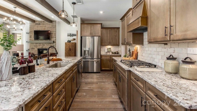 kitchen with a sink, dark wood finished floors, stainless steel appliances, custom range hood, and tasteful backsplash