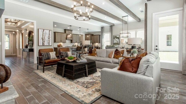 living room featuring dark wood-style flooring, a chandelier, plenty of natural light, and beam ceiling