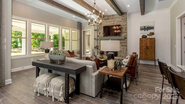 living area featuring an inviting chandelier, baseboards, beam ceiling, and dark wood-type flooring
