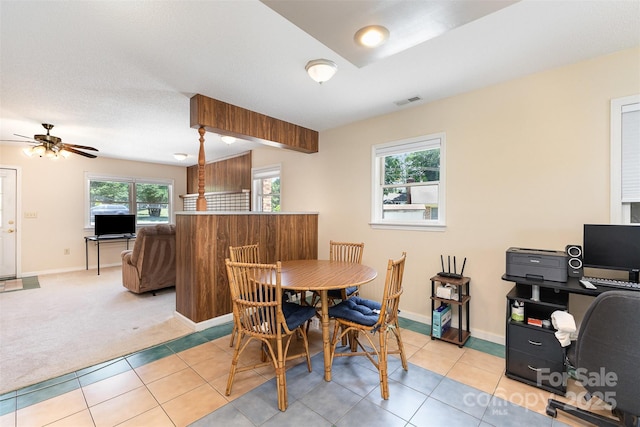 dining space featuring light tile patterned floors, a ceiling fan, light colored carpet, and visible vents