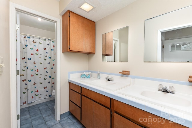 bathroom with double vanity, toilet, tile patterned floors, a shower with curtain, and a sink