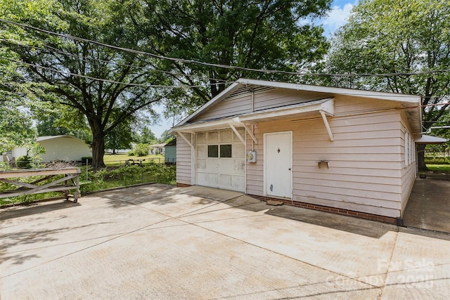 view of outdoor structure featuring concrete driveway and an outbuilding