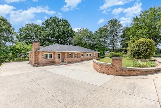 single story home featuring brick siding and a chimney