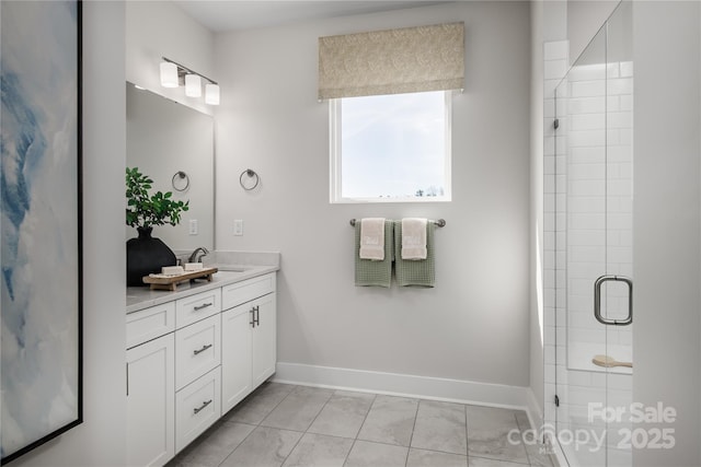 bathroom featuring an enclosed shower, baseboards, and vanity