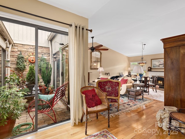 112 Deerlake Dr, Asheville, NC 28803 - sitting room featuring wood finished floors, a ceiling fan, a warm lit fireplace, and lofted ceiling