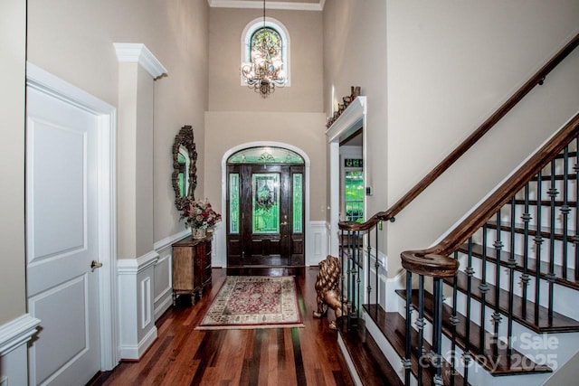 112 Eagle Chase Ln, Troutman, NC 28166 - entryway featuring dark wood finished floors, stairway, a chandelier, wainscoting, and a decorative wall