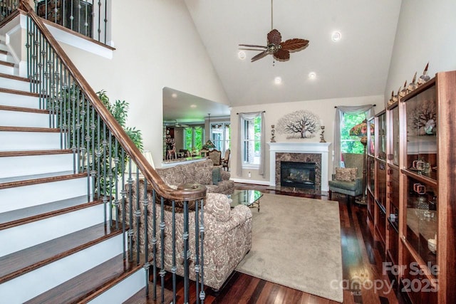 112 Eagle Chase Ln, Troutman, NC 28166 - living area with wood finished floors, high vaulted ceiling, stairway, ceiling fan, and a glass covered fireplace