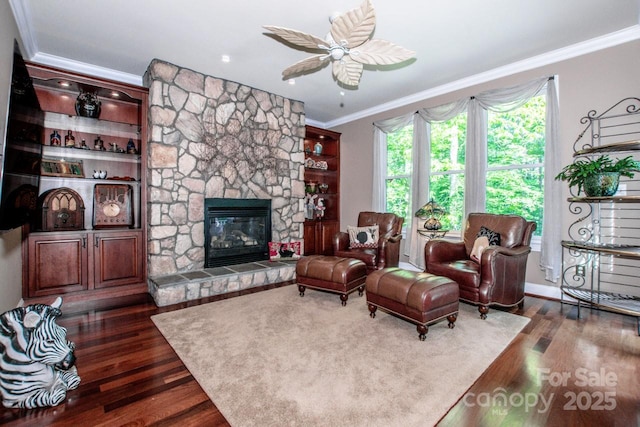 112 Eagle Chase Ln, Troutman, NC 28166 - living area featuring ornamental molding, dark wood-style flooring, a stone fireplace, and ceiling fan