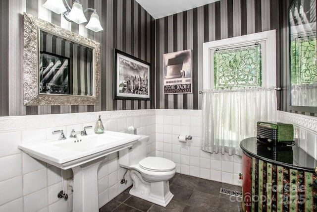 112 Eagle Chase Ln, Troutman, NC 28166 - bathroom featuring wallpapered walls, toilet, a wainscoted wall, tile patterned floors, and tile walls