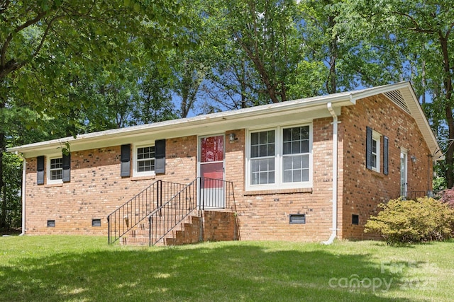 view of front of property featuring brick siding, crawl space, and a front yard