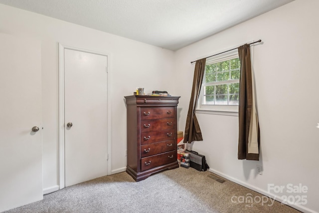 carpeted bedroom featuring baseboards and visible vents
