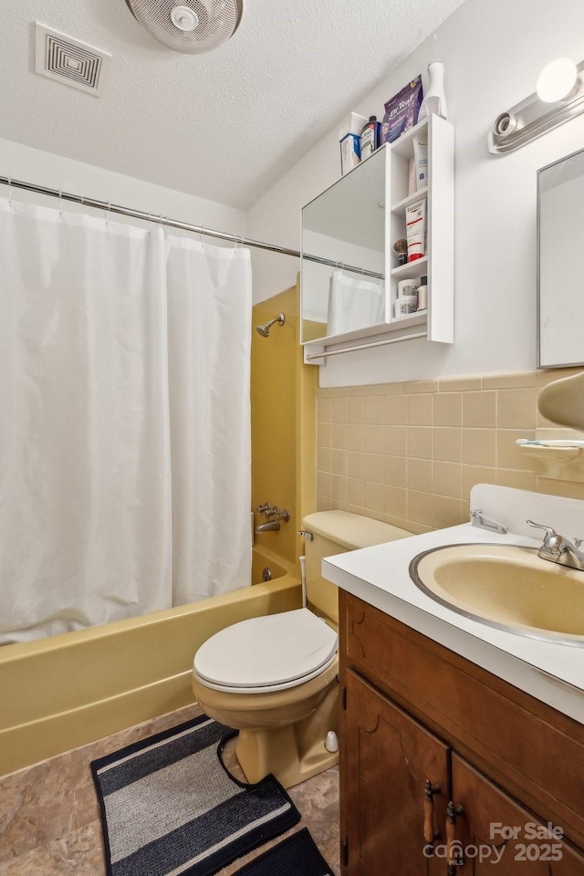 bathroom featuring a textured ceiling, visible vents, shower / tub combo, vanity, and toilet