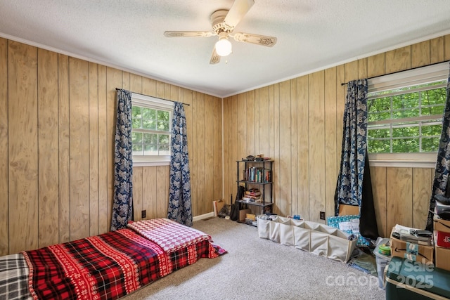 bedroom with wooden walls, carpet flooring, and a textured ceiling