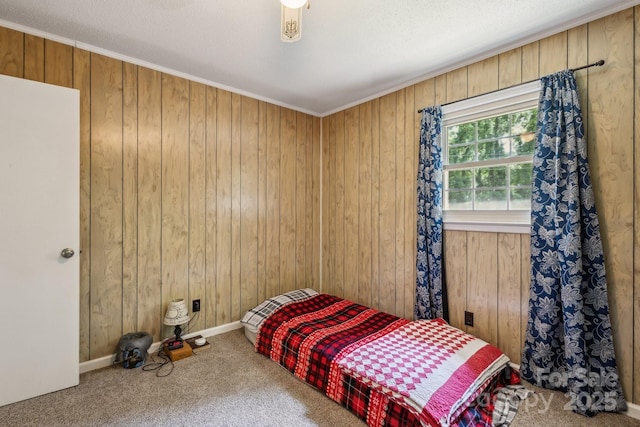 bedroom featuring wooden walls, baseboards, and carpet